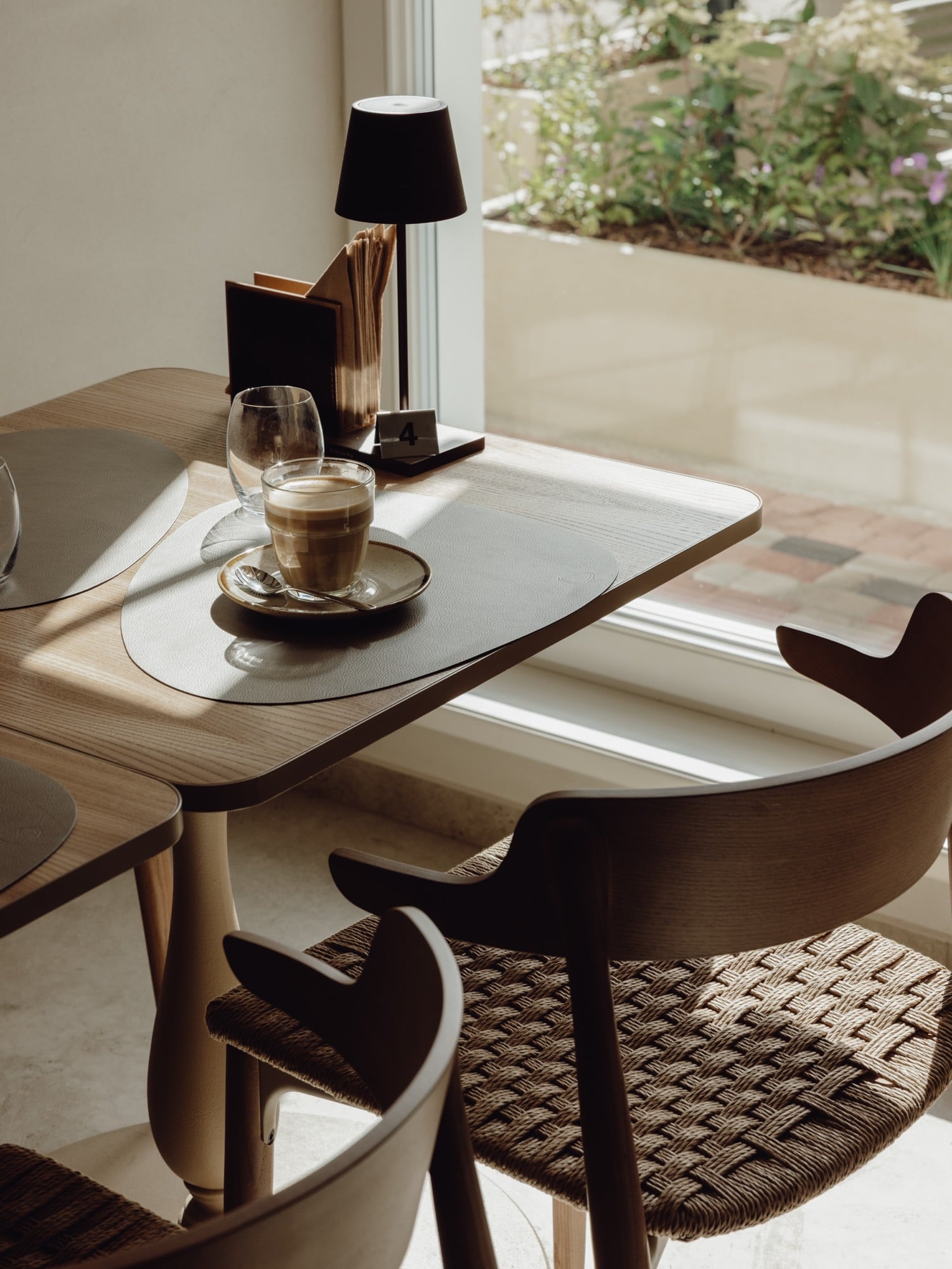 Konrāda Kafē — coffee on a sunlit table